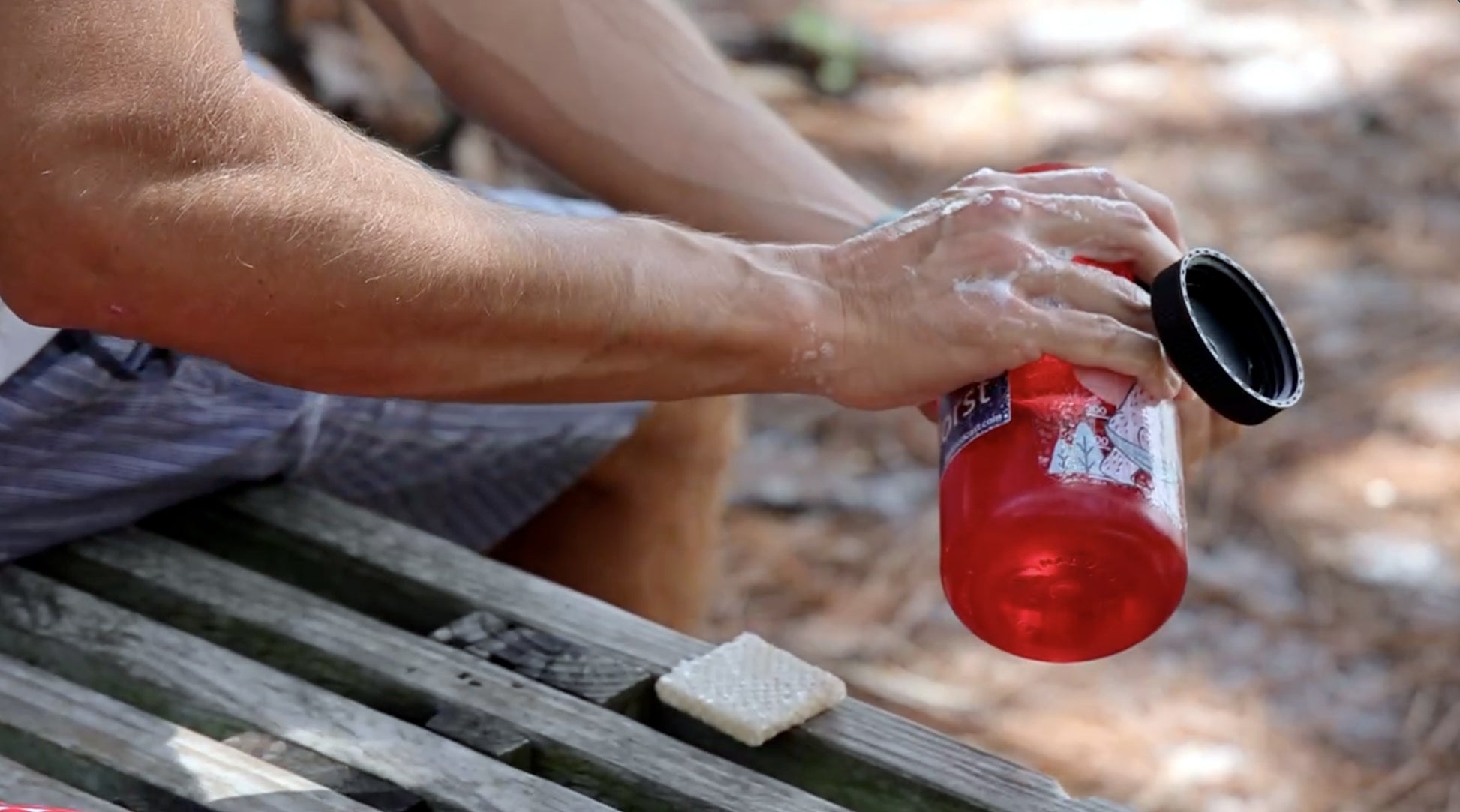 Nature Buff clear circle yeti sticker on red water bottle during an outdoor cleanup